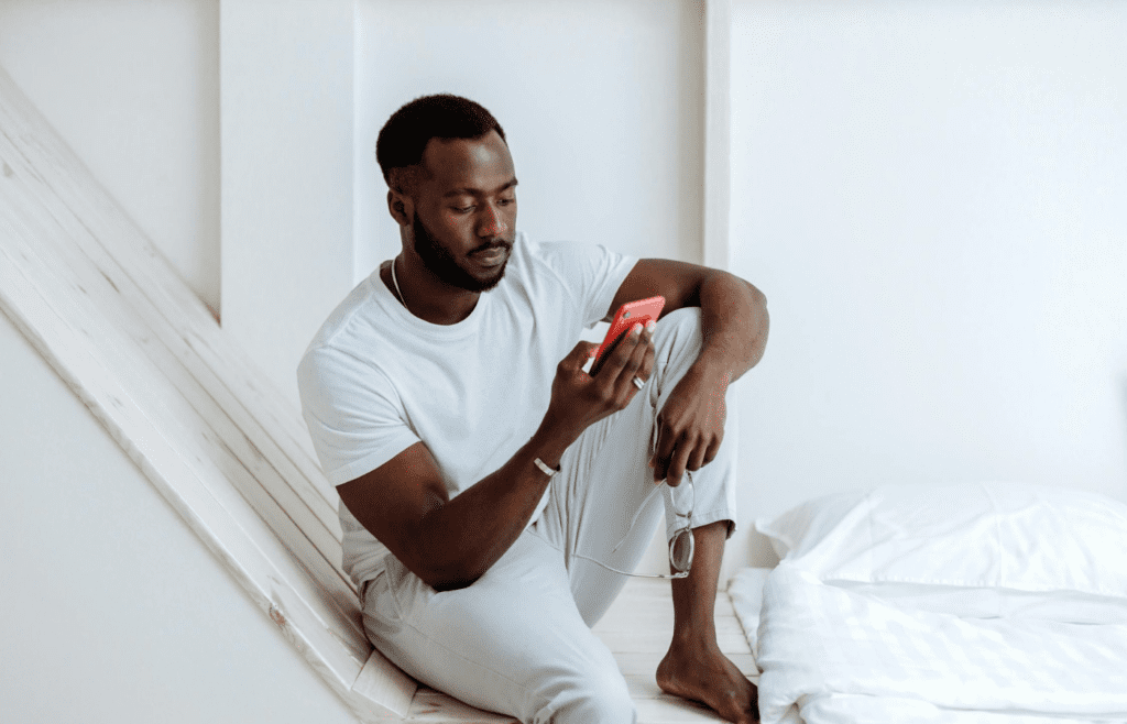 A person sitting alone, looking at a phone.