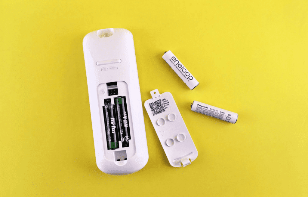 A pack of AA batteries next to a remote
