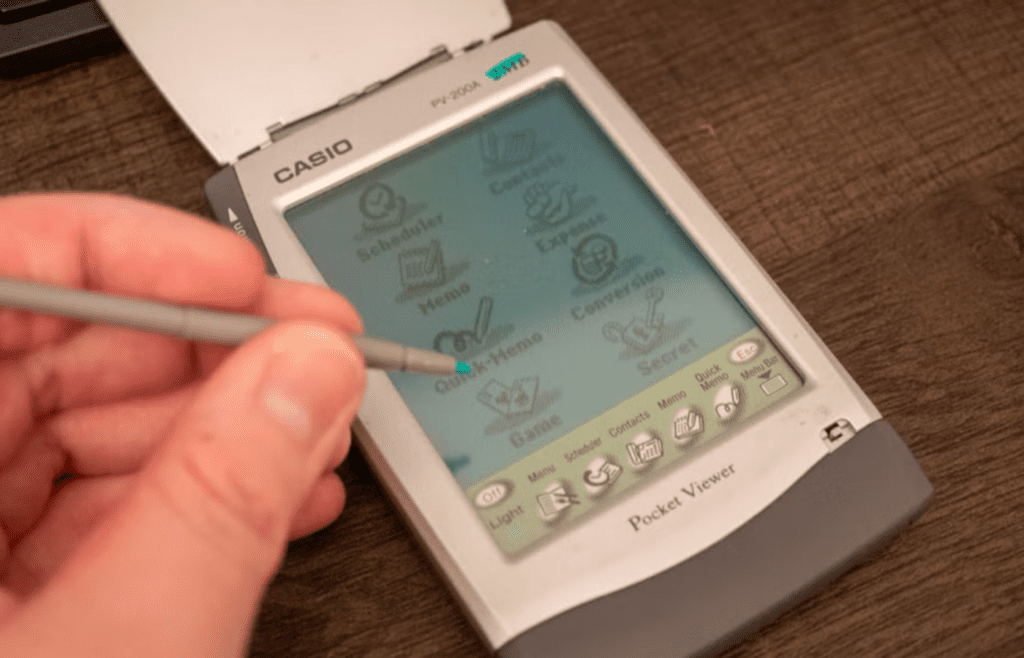 A stylus tapping on an old PDA screen