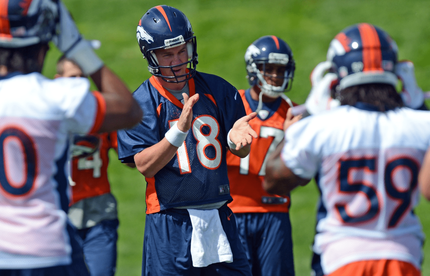 May 30, 2012; Englewood, CO, USA; Denver Broncos quarterback Peyton Manning (18) huddles with teammates before the start of organized team activities at the Broncos training facility. Mandatory Credit: Ron Chenoy-Imagn Images
