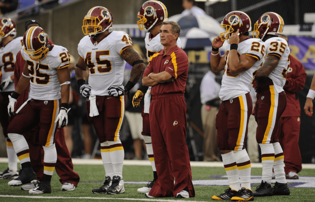 Washington Redskins head coach Mike Shanahan (center) watches his team warm up before a preseason game against the Baltimore Ravens at M&T Bank Stadium.