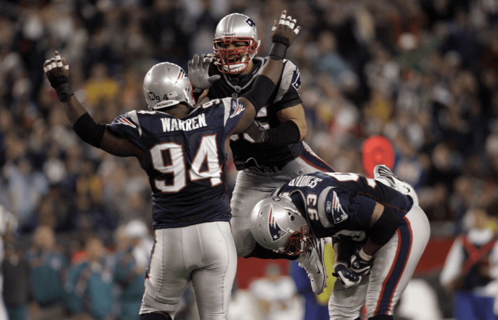 New England Patriots linebacker Junior Seau (55) celebrates with fellow team mates defensive lineman Ty Warren (94) and defensive lineman Richard Seymour (93) after a sack against the Miami Dolphins in the 4th quarter at Gillette Stadium.