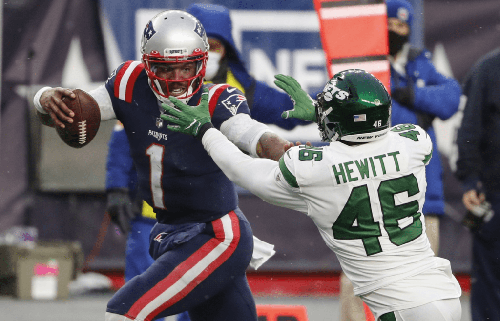 Jan 3, 2021; Foxborough, Massachusetts, USA; New England Patriots quarterback Cam Newton (1) fights off New York Jets linebacker Neville Hewitt (46) on his way to a touchdown during the second half at Gillette Stadium. Mandatory Credit: Winslow Townson-Imagn Images