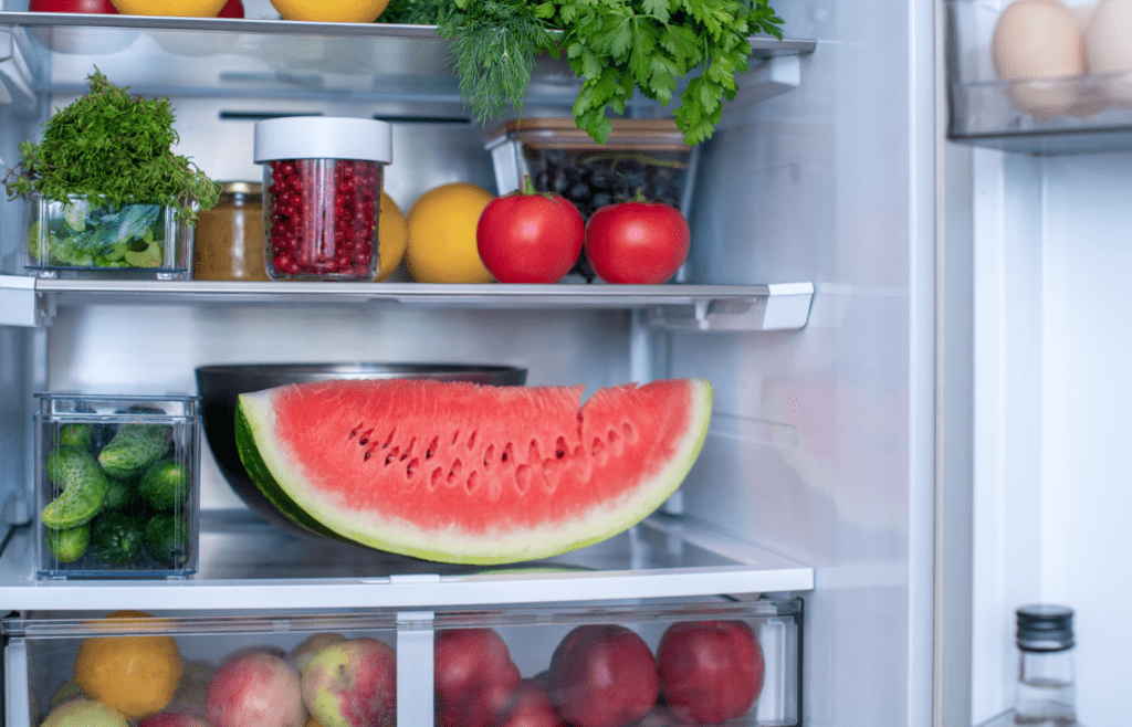 Plastic containers of sliced fruit in a refrigerated case