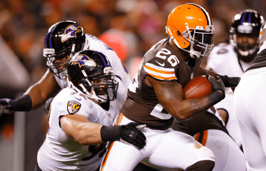 Nov 3, 2013; Cleveland, OH, USA; Cleveland Browns running back Willis McGahee (26) runs the ball as Baltimore Ravens nose tackle Haloti Ngata (92) wraps him up in the second half at FirstEnergy Stadium. Mandatory Credit: Rick Osentoski-Imagn Images