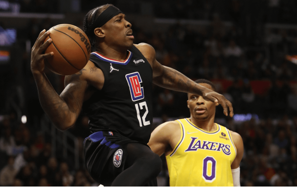 Feb 3, 2022; Los Angeles, California, USA; Los Angeles Clippers guard Eric Bledsoe (12) passes a ball against Los Angeles Lakers guard Russell Westbrook (0) during the fourth quarter at Crypto.com Arena. The Clippers won 111-110. Mandatory Credit: Kiyoshi Mio-Imagn Images