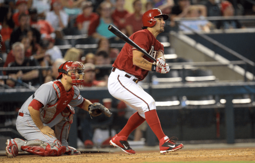 Jun 1, 2014; Phoenix, AZ, USA; Arizona Diamondbacks third baseman Eric Chavez (12) hits a sacrifice fly RBI in the fourth inning against the Cincinnati Reds at Chase Field. Mandatory Credit: Joe Camporeale-Imagn Images
