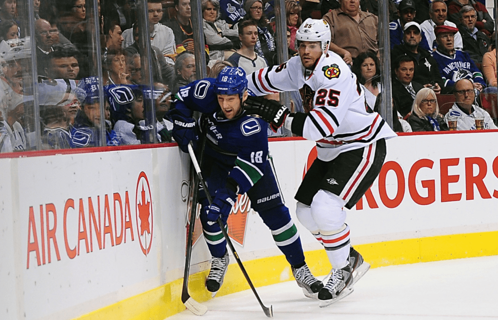 Apr 22, 2013; Vancouver, British Columbia, CAN; Vancouver Canucks defenseman Cam Barker (18) is boarded by Chicago Blackhawks forward Viktor Stalberg (25) during the second period at Rogers Arena. Mandatory Credit: Anne-Marie Sorvin-Imagn Images