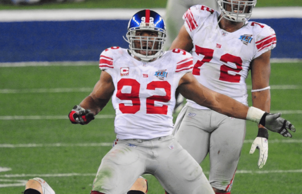 Feb 3, 2008; Glendale, AZ, USA; New York Giants defensive end Michael Strahan (92) celebrates a sack on New England Patriots quarterback Tom Brady (12) during Super Bowl XLII at the University of Phoenix Stadium. Mandatory Credit: Mark J. Rebilas-Imagn Images