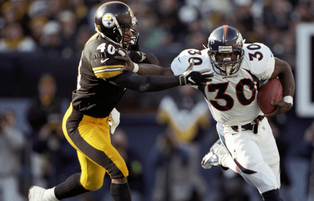 Jan 11, 1998; Pittsburgh, PA, USA; FILE PHOTO; Denver Broncos running back Terrell Davis (30) fighting off Pittsburgh Steelers safety Myron Bell (40) during the 1998 AFC Championship Game where Denver defeated Pittsburgh 24-21 at Three Rivers Stadium. Mandatory Credit: RVR Photos-Imagn Images