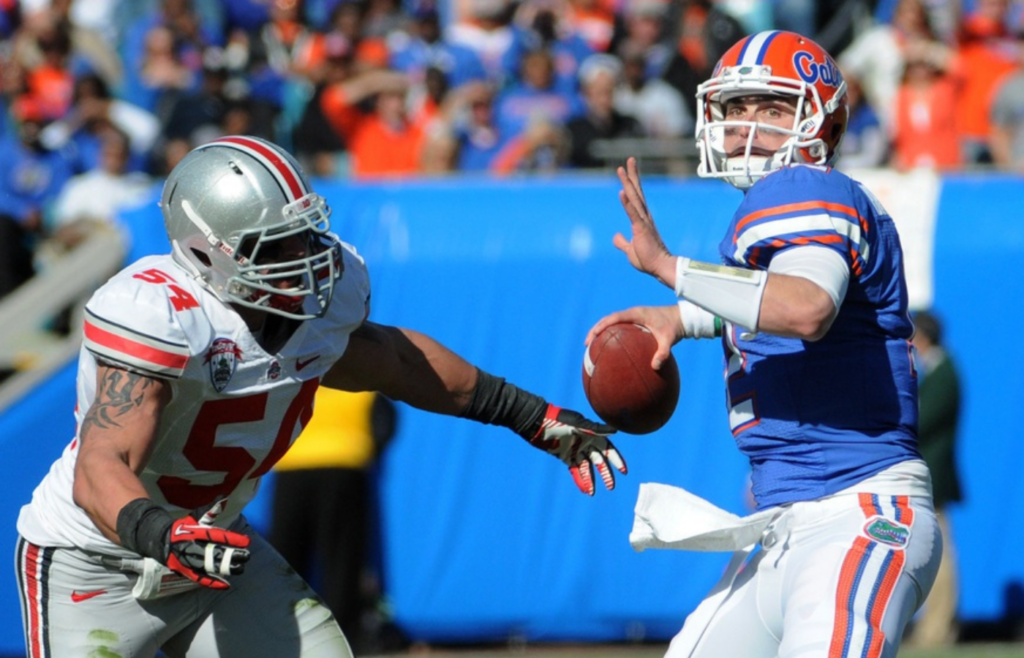 Jan 2, 2012; Tallahassee, FL, USA; Florida Gators quarterback John Brantley (12) throws the ball in front of Ohio State Buckeyes defensive tackle John Simon (54) during the first quarter of the 2012 Gator Bowl at EverBank Field. Mandatory Credit: Melina Vastola-Imagn Images