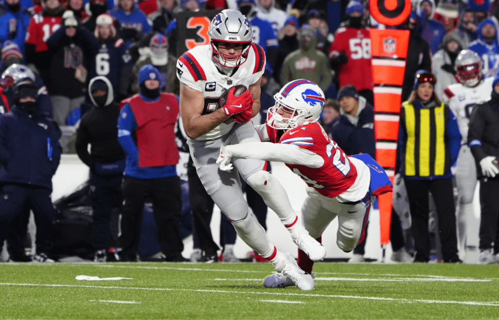 Dec 22, 2024; Orchard Park, New York, USA; New England Patriots tight end Hunter Henry (85) breaks a tackle attempt by Buffalo Bills safety Cole Bishop (24) after making a catch during the first half at Highmark Stadium. Mandatory Credit: Gregory Fisher-Imagn Images