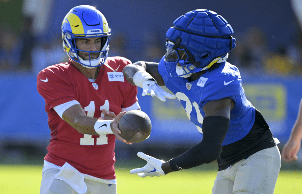 Jul 29, 2024; Los Angeles, CA, USA; Los Angeles Rams quarterback Jimmy Garoppolo (11) hands off to running back Zach Evans (21) during training camp at Loyola Marymount University. Mandatory Credit: Jayne Kamin-Oncea-Imagn Images