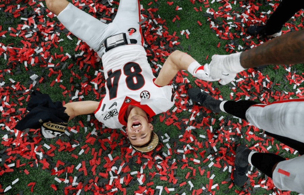 Georgia Bulldogs wide receiver Ladd McConkey (84) lays in confetti after winning the College Football Playoff National Championship on Monday, Jan. 10, 2022, at Lucas Oil Stadium in Indianapolis. The Georgia Bulldogs defeated the Alabama Crimson Tide in the College Football playoff National Championship, 33-18, earning the title for the first time in 41 years. They clinched the win with several touchdowns in the fourth quarter. A 40-yard touchdown by Adonai Mitchell (5), pictured second, gave Georgia a 19-18 lead with 8:09 left in the game. Next came a 15-yard touchdown by Brock Bowers (19) with 3:33 left, and finally, Kelee Ringo (5) intercepted from Alabama and ran for a 79-yard touchdown with about a minute on the clock, sealing the deal for Georgia. Indystar Photojournalist Jenna Watson S Best Photos Of 2022