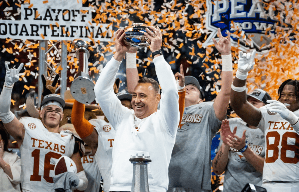 Texas Longhorns head coach Steve Sarkisian raises the trophy as the Texas Longhorns celebrate their 39-31 double overtime win over the Arizona State Sun Devils in the Peach Bowl College Football Playoff quarterfinal at Mercedes-Benz Stadium in Atlanta, Georgia, Jan. 1, 2025