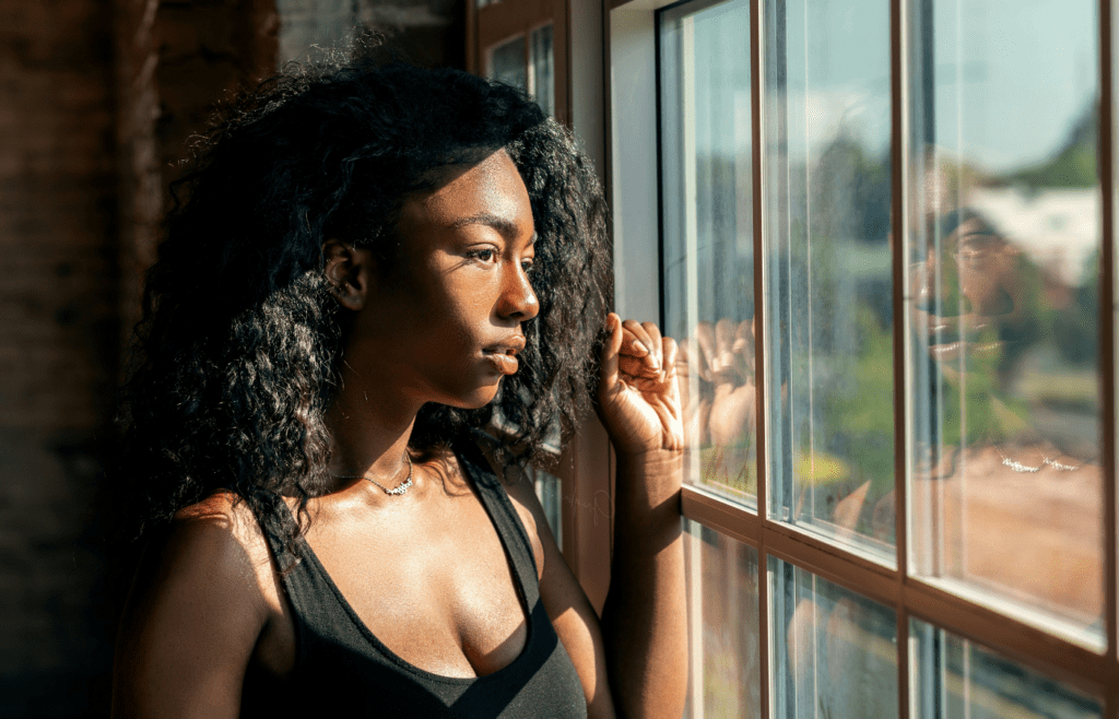 A person gazing out of a window, lost in thought.