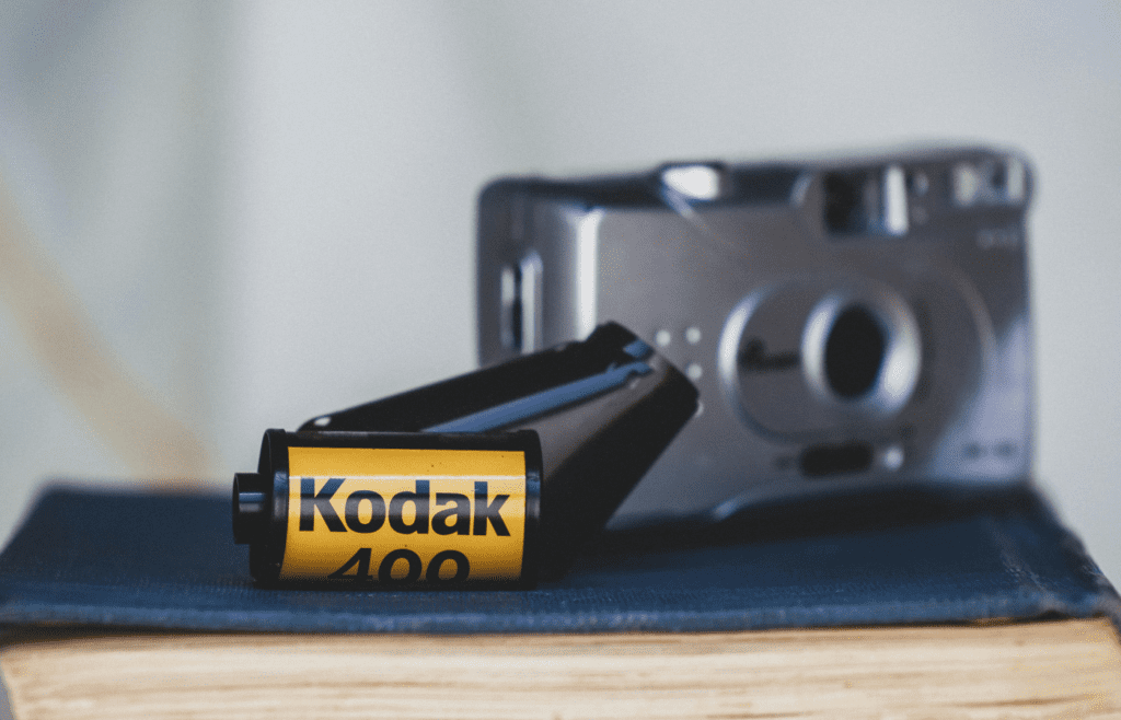 35mm film rolls on a table next to a disposable camera