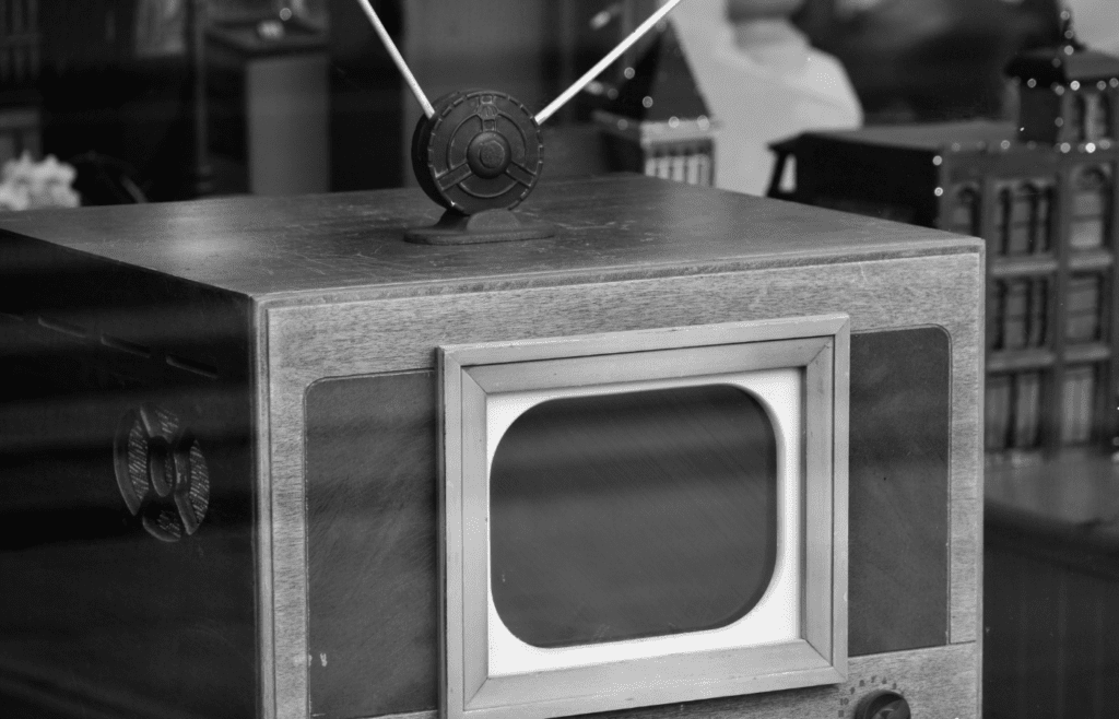 A TV with knobs and rabbit ear antennas