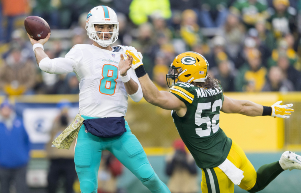 Nov 11, 2018; Green Bay, WI, USA; Miami Dolphins quarterback Brock Osweiler (8) throws a pass under pressure from Green Bay Packers linebacker Clay Matthews (52) during the first quarter at Lambeau Field. Mandatory Credit: Jeff Hanisch-Imagn Images