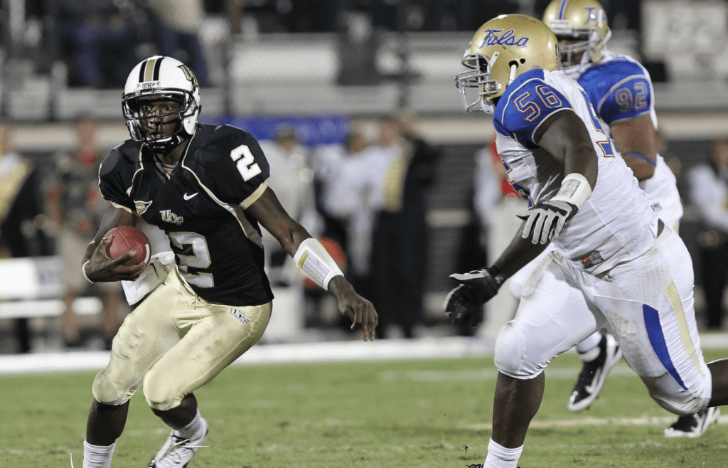 November 3, 2011; Orlando FL, USA; UCF Knights quarterback Jeff Godfrey (2) runs with the ball as Tulsa Golden Hurricane defensive tackle Daeshon Bufford (56) defends during the second quarter at Bright House Networks Stadium. Mandatory Credit: Kim Klement-Imagn Images