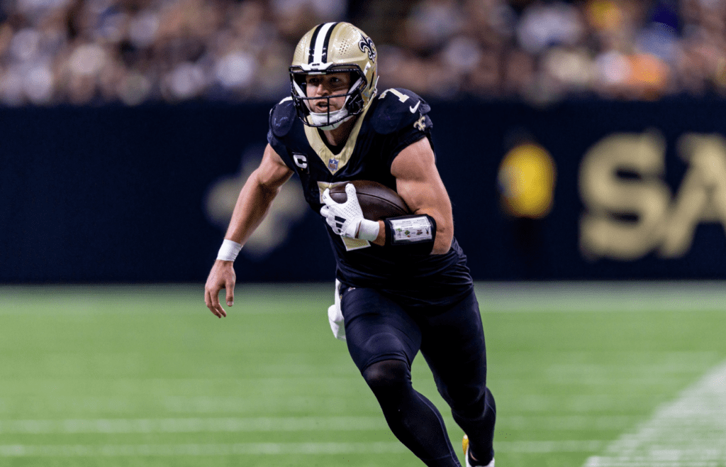 Dec 1, 2024; New Orleans, Louisiana, USA; New Orleans Saints tight end Taysom Hill (7) rushes against the Los Angeles Rams during the first half at Caesars Superdome. Mandatory Credit: Stephen Lew-Imagn Images