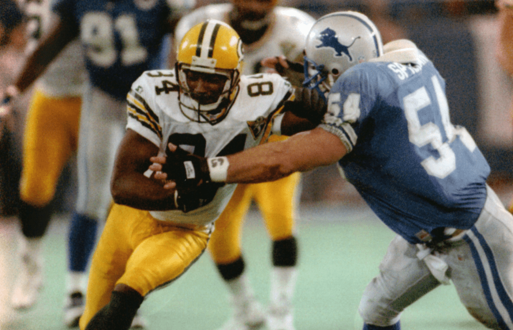 Green Bay Packers wide receiver Sterling Sharpe tries to elude Chris Spielman of the Detroit Lions after catching his 109th pass of the season during the second quarter of their game on January 1, 1994. Sharpe broke his NFL record of 108 with the catch.