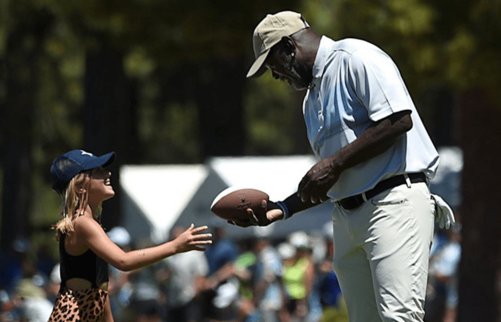 NFL Hall of Fame member Emmitt Smith signs a football for a young Dallas Cowboys fan during the American Century Championship golf tournament at the Edgewood Tahoe Golf Course in Stateline on July 14, 2023.