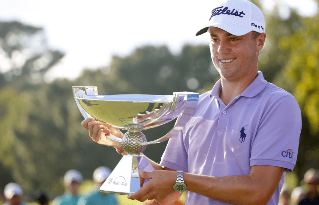 Sep 24, 2017; Atlanta, GA, USA; Justin Thomas hoists the trophy after winning the FedEx Cup following the Tour Championship golf tournament at East Lake Golf Club. Mandatory Credit: Butch Dill-Imagn Images