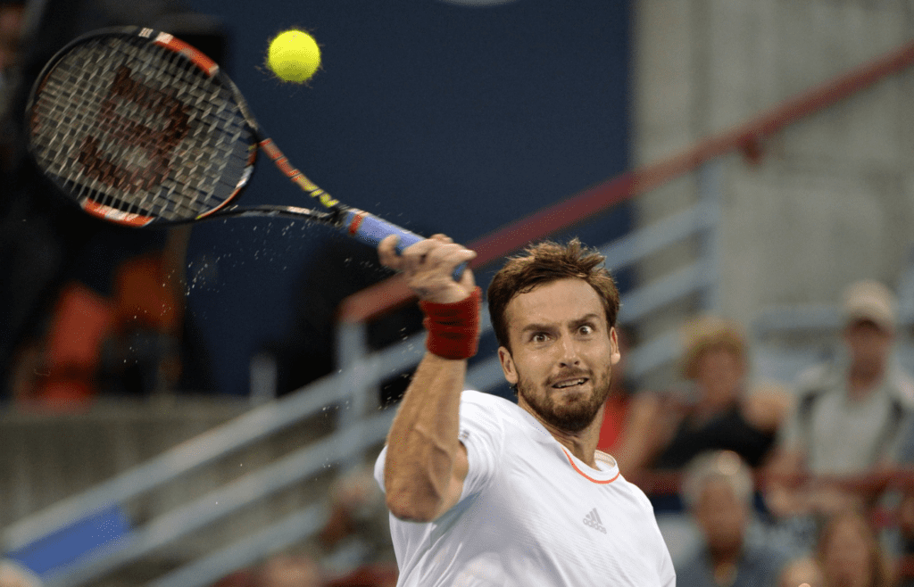 Aug 14, 2015; Montreal, Quebec, Canada; Ernests Gulbis of Latvia hits the ball against Novak Djokovic of Serbia (not pictured) during the Rogers Cup tennis tournament at Uniprix Stadium. Mandatory Credit: Eric Bolte-Imagn Images