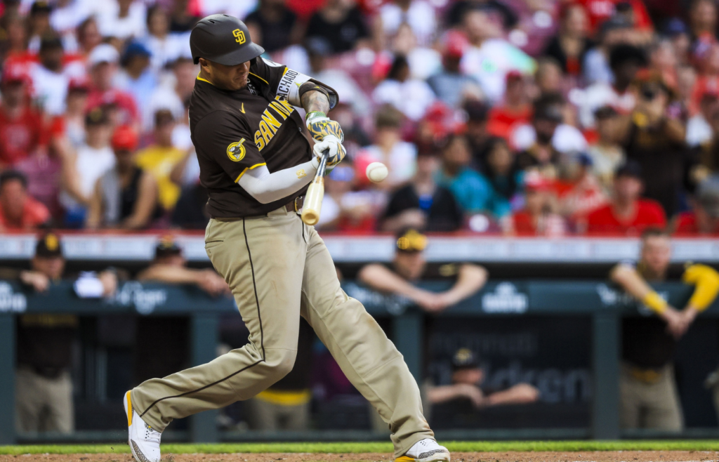 Jun 28, 2025; Cincinnati, Ohio, USA; San Diego Padres third baseman Manny Machado (13) hits a single in the eighth inning against the Cincinnati Reds at Great American Ball Park. Mandatory Credit: Katie Stratman-Imagn Images