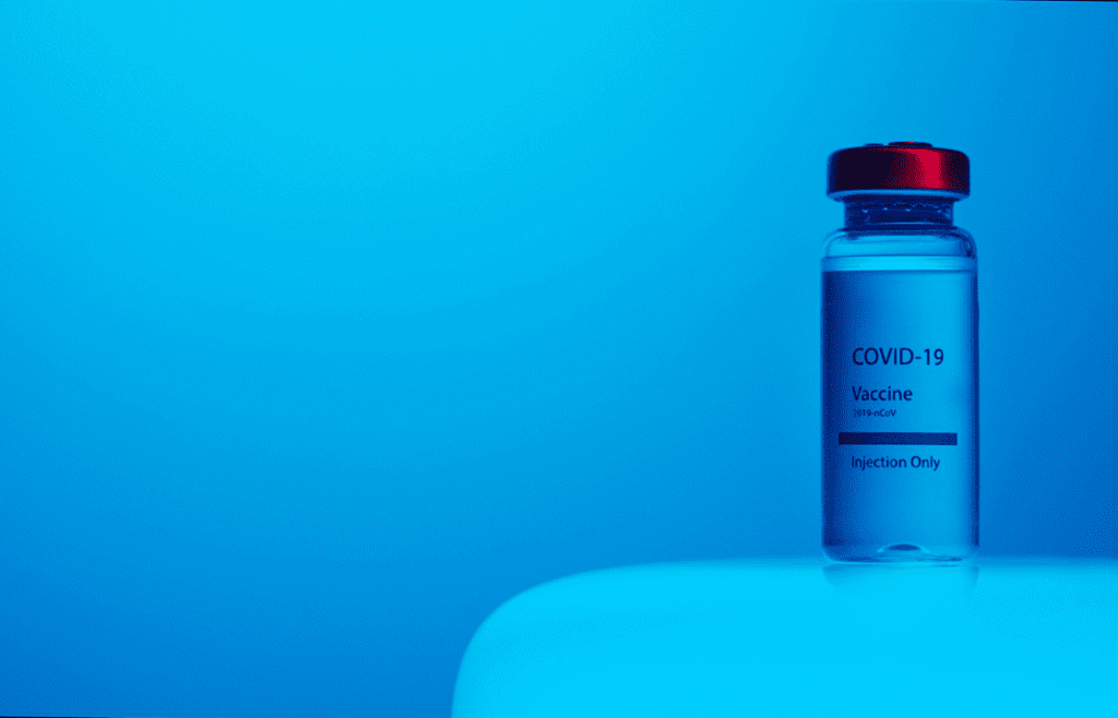 A Close-Up View of a Covid-19 Vaccine Vial on Blue Background