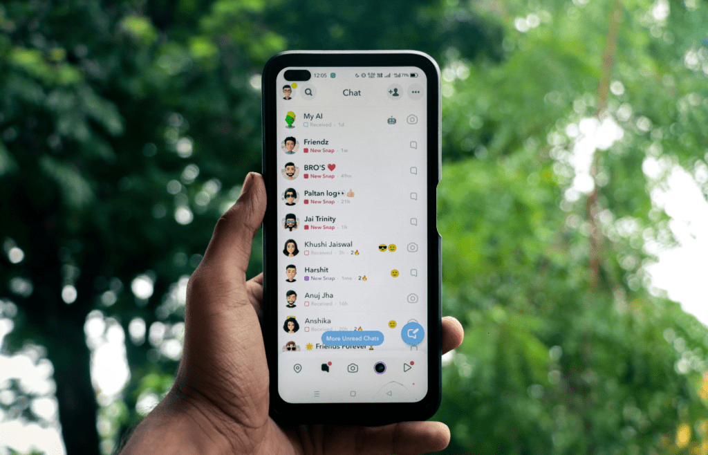 Man holding a iPhone X with social network service Snapchat on the screen