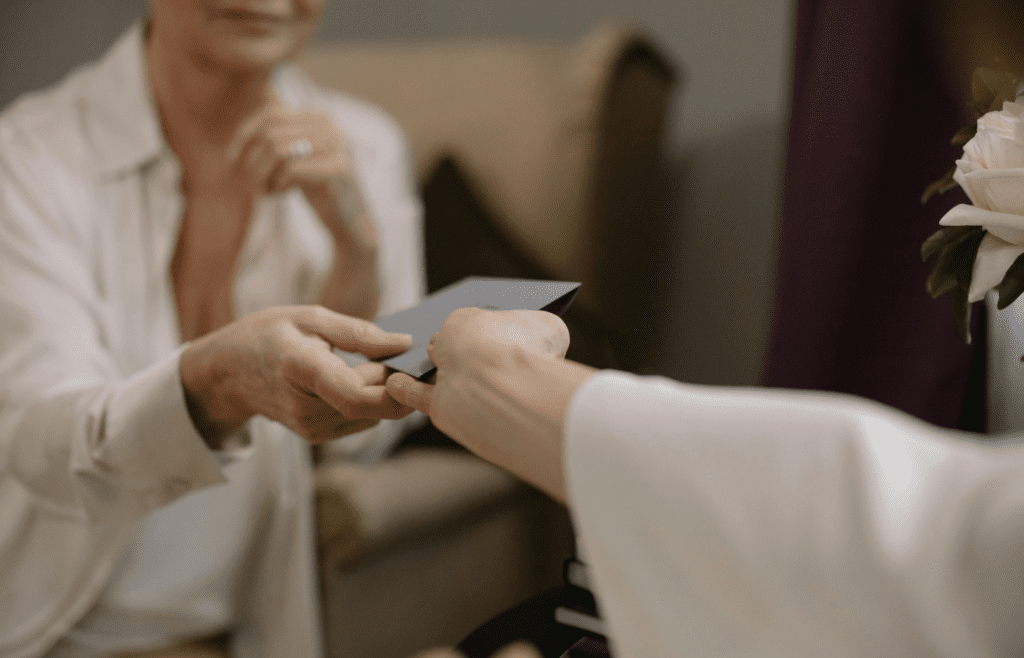 A Person Giving an Invitation Card to a Woman