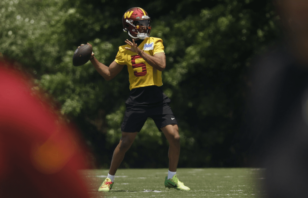 Washington Commanders quarterback Jayden Daniels (5) passes the ball on day one of minicamp at Commanders Park.