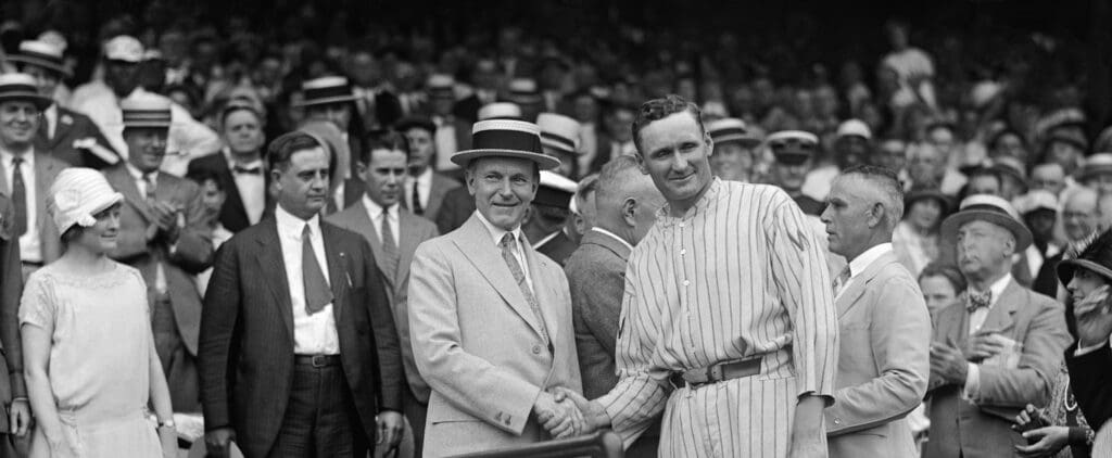 President Calvin Coolidge (left) and Washington Senators pitcher Walter Johnson (right) shake hands.