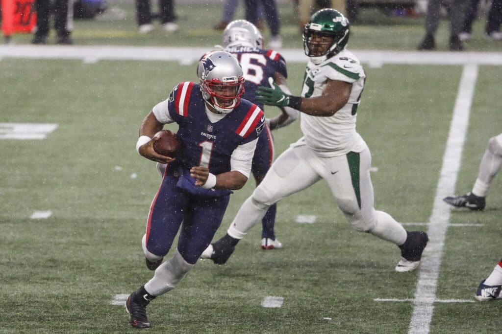 Jan 3, 2021; Foxborough, Massachusetts, USA; New England Patriots quarterback Cam Newton (1) runs past New York Jets defensive tackle Nathan Shepherd (97) during the second half at Gillette Stadium. Mandatory Credit: Winslow Townson-USA TODAY Sports