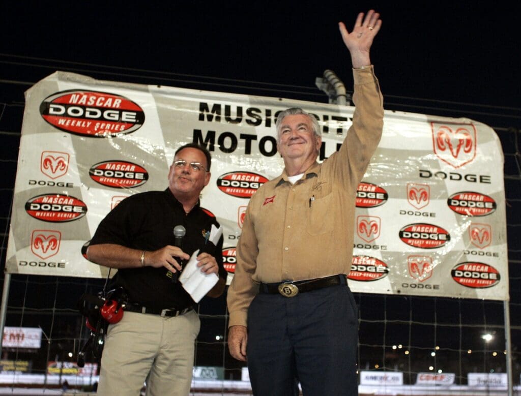 NASCAR racing legend Bobby Allison, right, waves to the crowd after being introduced as the grand marshal during the season-opening races at Music City Motorplex in Nashville on April 8, 2005.