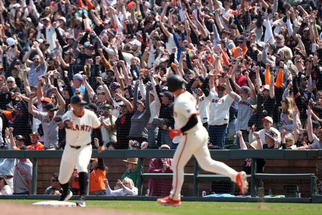 May 3, 2025; San Francisco, California, USA; San Francisco Giants fans cheer after a grand slam home run by third baseman Matt Chapman (foreground center) against the Colorado Rockies during the sixth inning at Oracle Park. Mandatory Credit: Darren Yamashita-Imagn Images