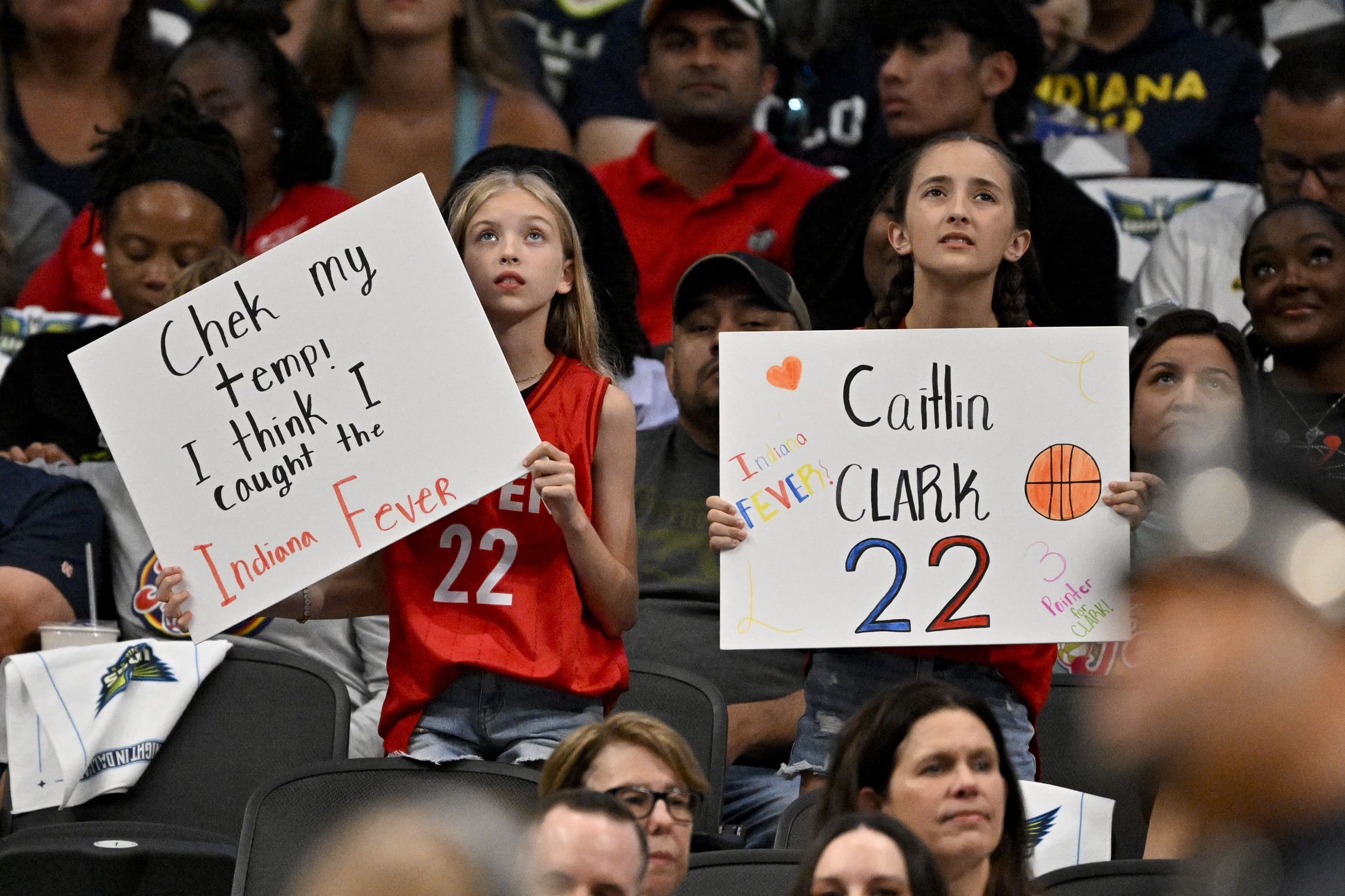 Jun 27, 2025; Dallas, Texas, USA; Fans of Indiana Fever guard Caitlin Clark (22) hold up signs during the first quarter against the Dallas Wings at the American Airlines Center. Mandatory Credit: Jerome Miron-Imagn Images