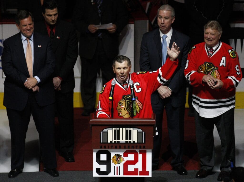March 7, 2008; Chicago, IL, USA; Chicago Blackhawks former player Stan Mikita (21) addresses the crowd as he stands in front of fellow former player Bobby Hull (9) and team officials during a ceremony honoring their careers before the game against the San Jose Sharks at the United Center. Mandatory Credit: Jerry Lai-USA TODAY Sports