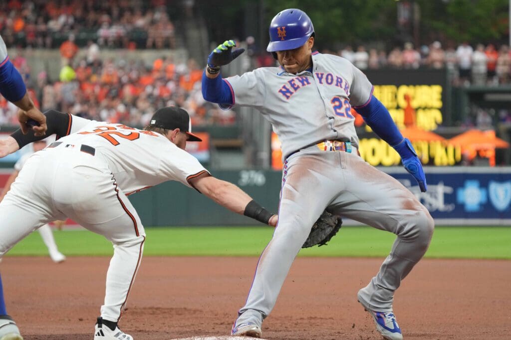 Jul 8, 2025; Baltimore, Maryland, USA; New York Mets outfielder Juan Soto (22) avoids a pickoff tag during the fourth inning by Baltimore Orioles first baseman Ryan O’Hearn (32) at Oriole Park at Camden Yards. Mandatory Credit: Mitch Stringer-Imagn Images