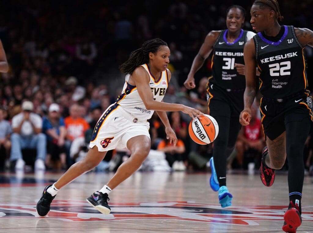 Jul 15, 2025; Boston, Massachusetts, USA; Indiana Fever guard Kelsey Mitchell (0) drives the ball against Connecticut Sun guard Saniya Rivers (22) in the second quarter at TD Garden. Mandatory Credit: David Butler II-Imagn Images