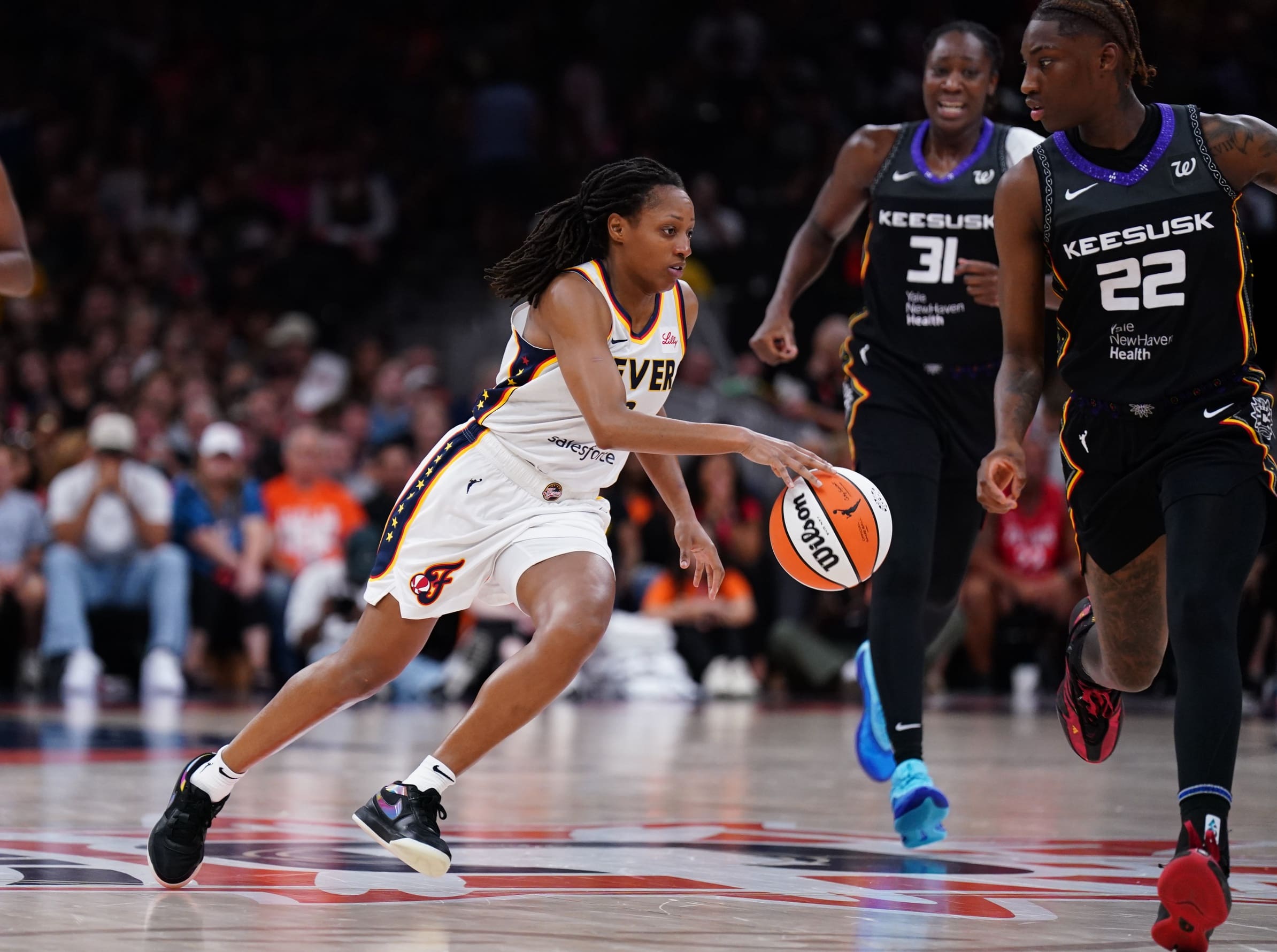Jul 15, 2025; Boston, Massachusetts, USA; Indiana Fever guard Kelsey Mitchell (0) drives the ball against Connecticut Sun guard Saniya Rivers (22) in the second quarter at TD Garden. Mandatory Credit: David Butler II-Imagn Images