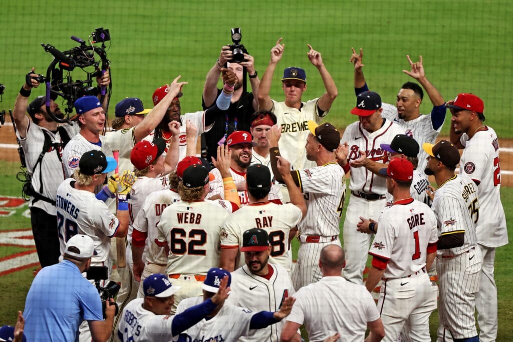 Jul 15, 2025; Cumberland, Georgia, USA; National League designated hitter Kyle Schwarber (12) of the Philadelphia Phillies celebrates with his teammates after hitting in the swing off after the 2025 MLB All Star Game ended in a tie at Truist Park. Mandatory Credit: Jordan Godfree-Imagn Images