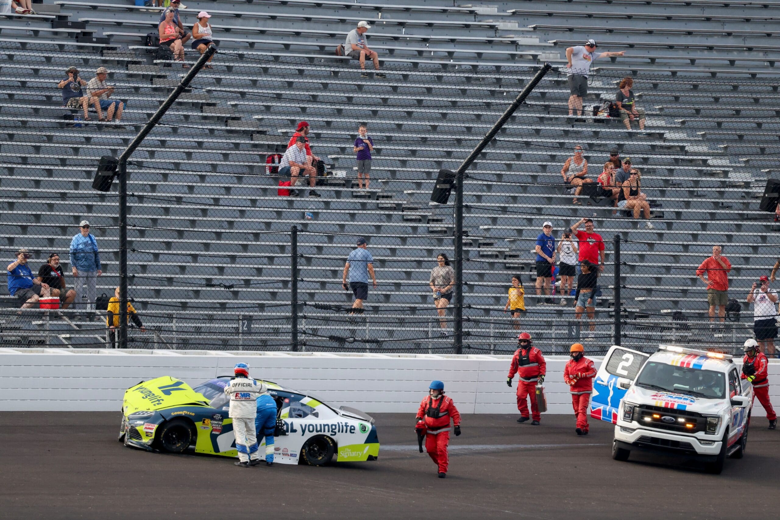 Emergency workers tend to NASCAR Xfinity Series driver Aric Almirola (19) after a crash with NASCAR Xfinity Series driver Austin Hill (21) on Saturday, July 26, 2025, during the Pennzoil 250 at Indianapolis Motor Speedway.