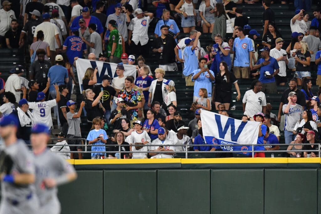 Jul 26, 2025; Chicago, Illinois, USA; Chicago Cubs fans celebrate and hold up W flags after their team defeated the Chicago White Sox at Rate Field. Mandatory Credit: Patrick Gorski-Imagn Images