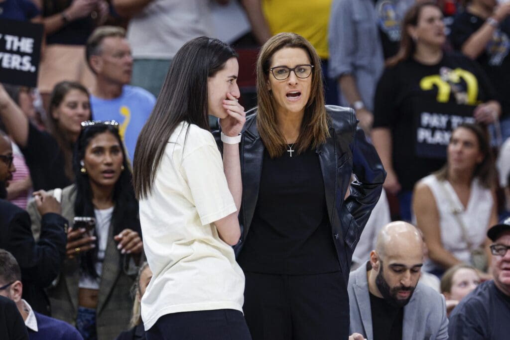 Jul 27, 2025; Chicago, Illinois, USA; Indiana Fever head coach Stephanie White (R) talks to injured guard Caitlin Clark (L) before a basketball game against the Chicago Sky at United Center. Mandatory Credit: Kamil Krzaczynski-Imagn Images