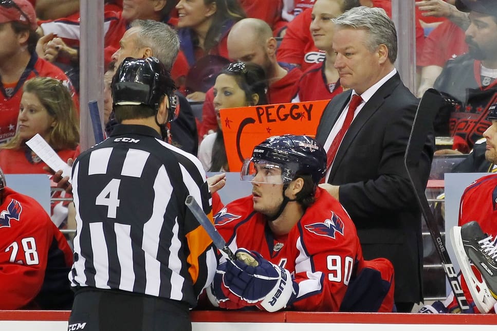 April 16, 2012; Washington, DC, USA; Washington Capitals head coach Dale Hunter (r) talks with referee Wes McCauley (4) from the bench against the Boston Bruins during the first period of game three of the 2012 Eastern Conference quarterfinals at Verizon Center. The Bruins won 4-3. Mandatory Credit: Geoff Burke-USA TODAY Sports