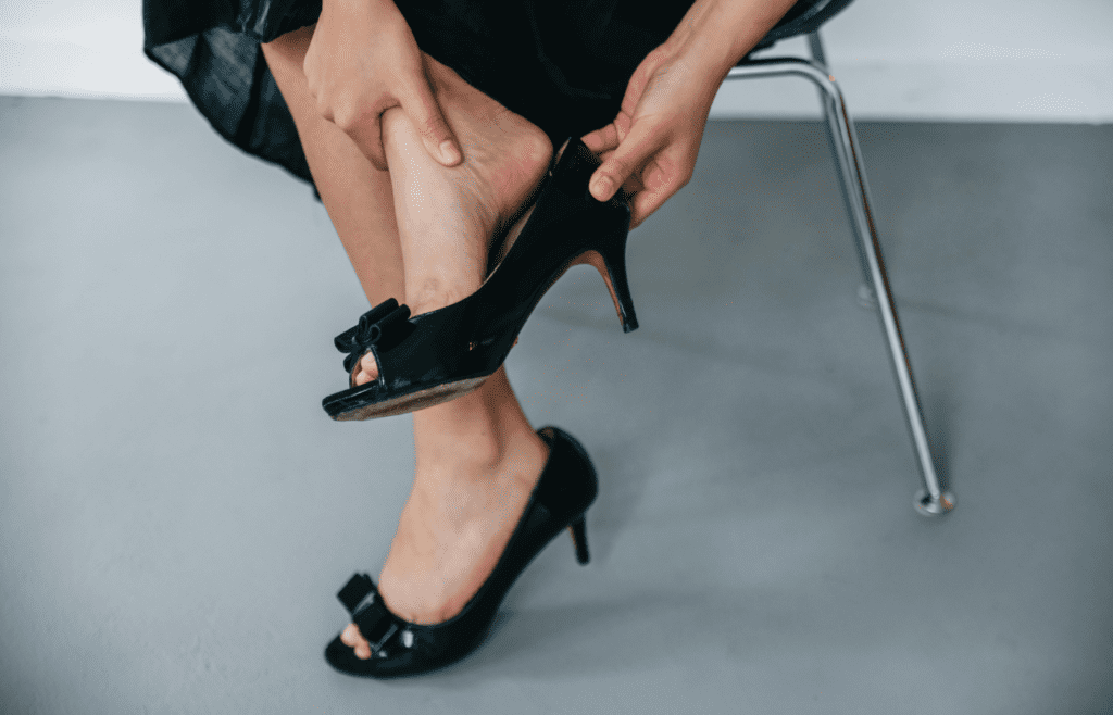 Photo of a Woman Removing a Black Shoe
