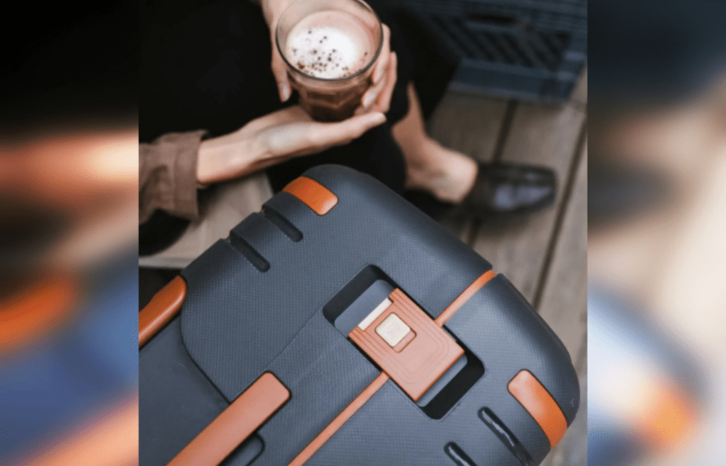 Person Hands Holding Glass of Coffee over Suitcase at Airport